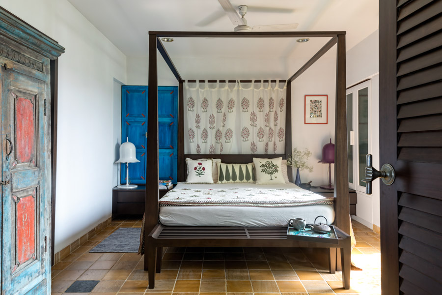 Four-poster bed decorated with block-printed curtain, a bright blue wooden panel creates a colourful Indian vibe in your bedroom - Beautiful Homes