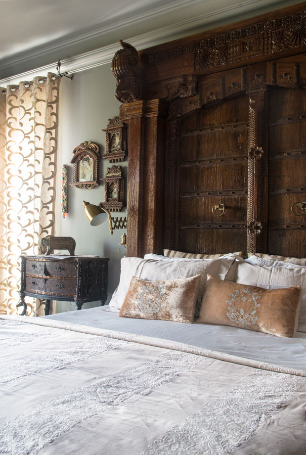 Rich wooden door serving as headboard in a heavily decorated Indian bedroom design out of a folktale - Beautiful Homes