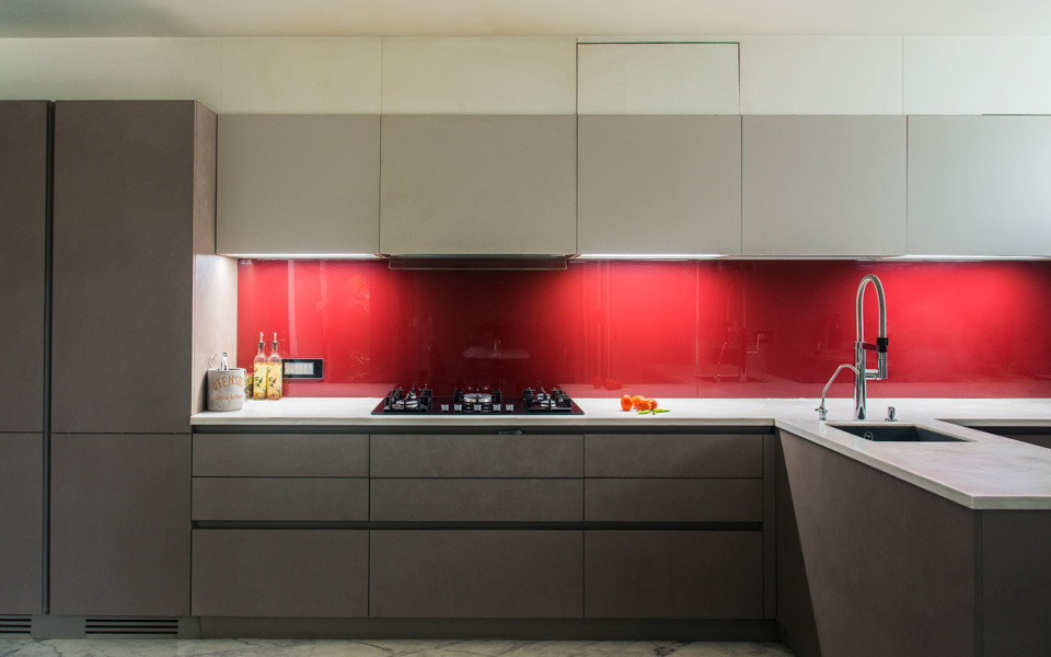 Modern kitchen design with bright red backsplash in glossy finish in a muted kitchen
