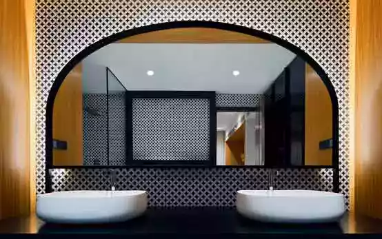 A bathroom mirror design shaped like a headboard in a retro-modern style
