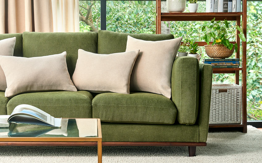 Living room with a green sofa and beige cushions