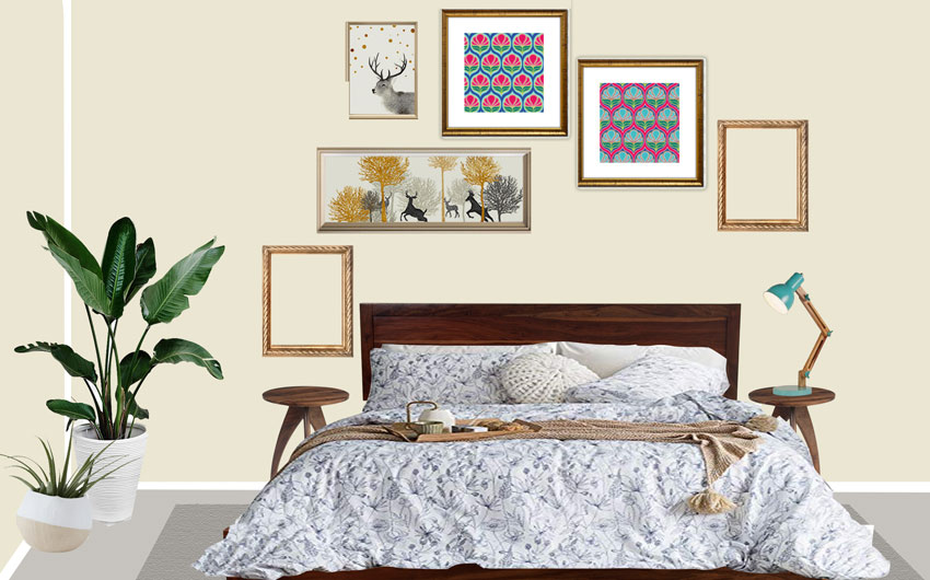 An off white bedroom with six art prints on the wall behind, three planters in one corner and a couple of side tables with a lamp places in one of them