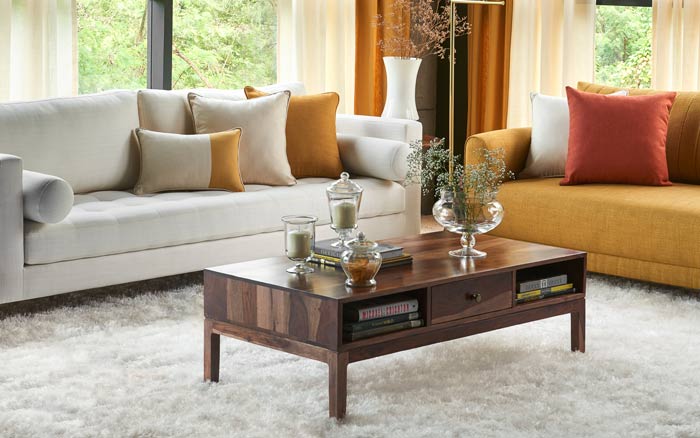 Living room with a white and a yellow sofa, a white rug and a wooden centre table