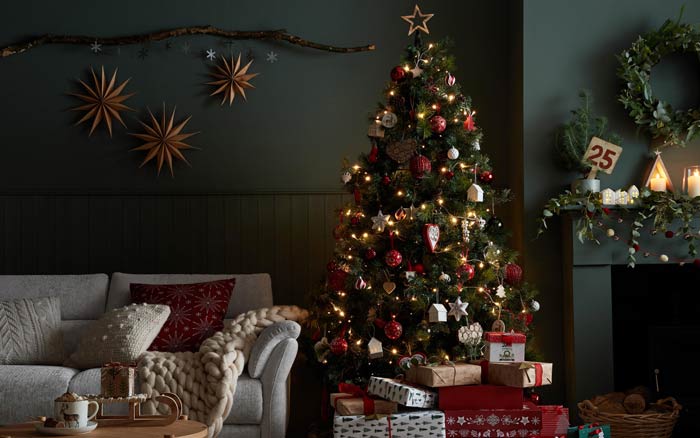 Green living room with a large sofa a and a Christmas Tree