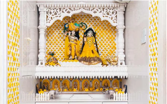 A pooja room in a home with Idols of Radha Krishna