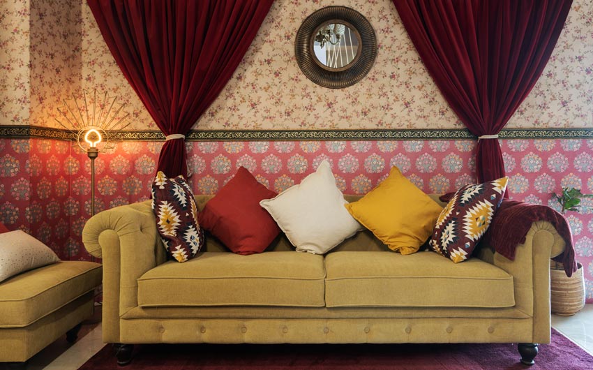 A wallpapered Living room with a yellow sofa and red curtains
