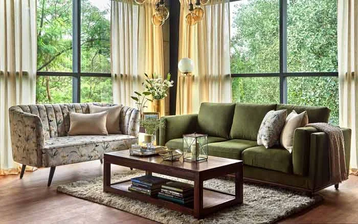 A living room with french windows, a green sofa, along with another sofa with floral upholstery