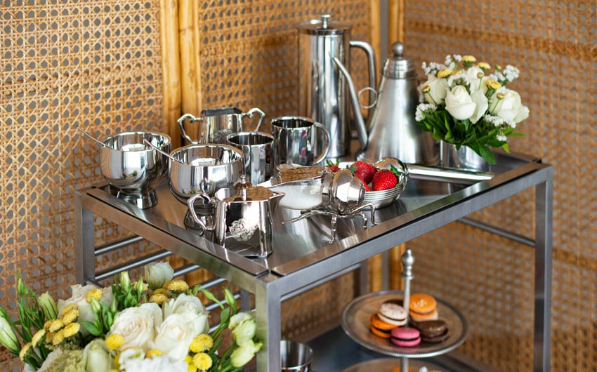 A trolley filled with stainless steel utensils and flowers