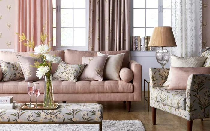 A living room with a beige sofa with a lot of cushions on it