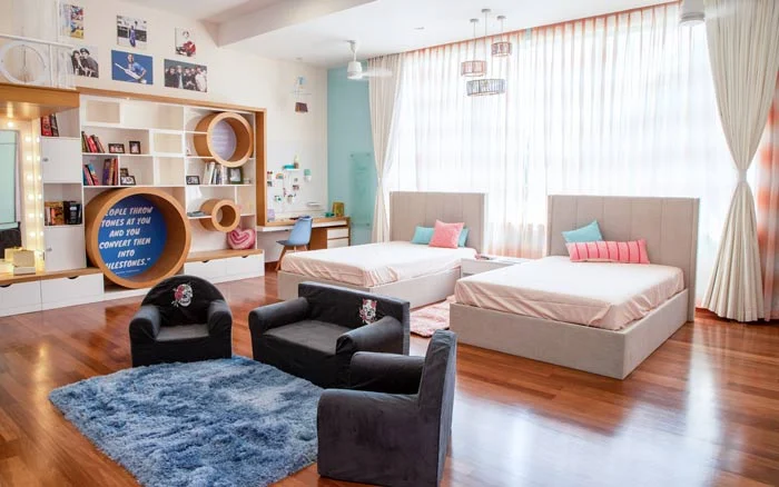Kids room with two beds and a grey sofa set
