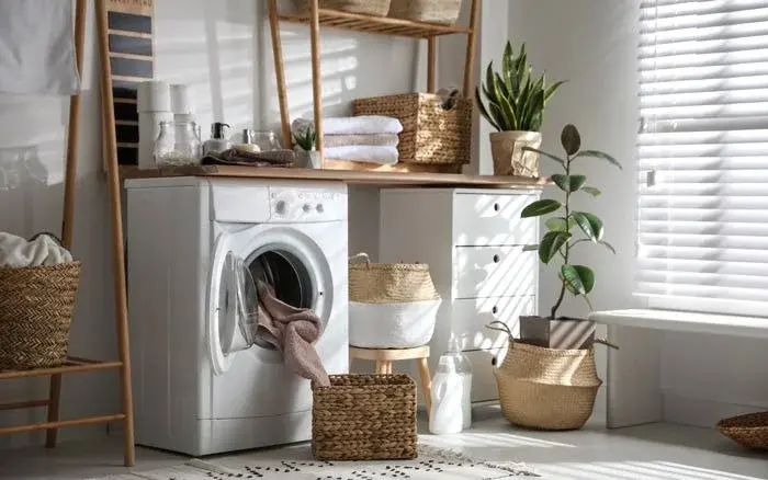 White room with a washing machine and planters