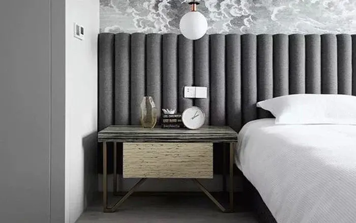 A grey bedroom with a grey headboard