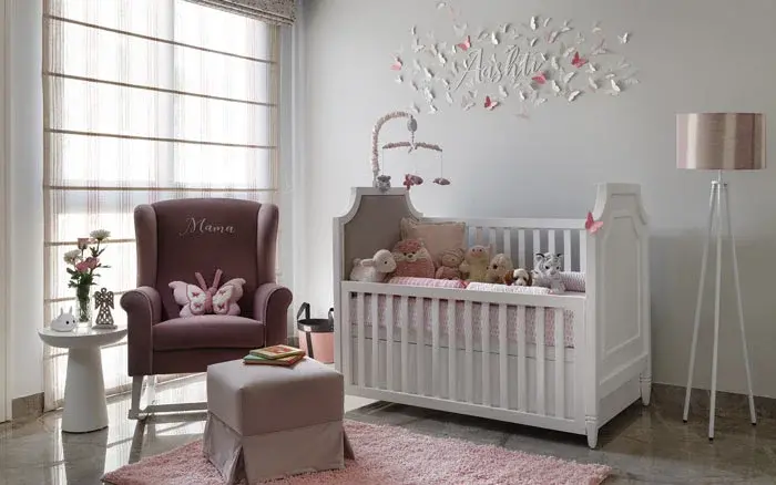 A nursery with a white wooden bed and a red chair