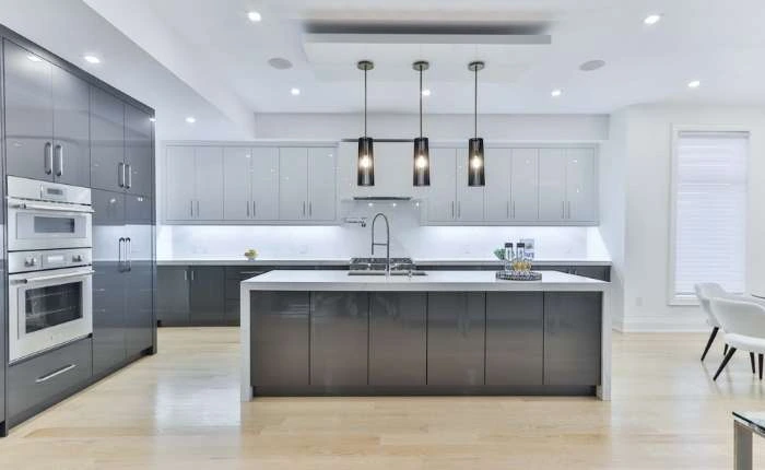 Monochromatic modular kitchen design with kitchen island &amp; bright kitchen lighting - Beautiful Homes