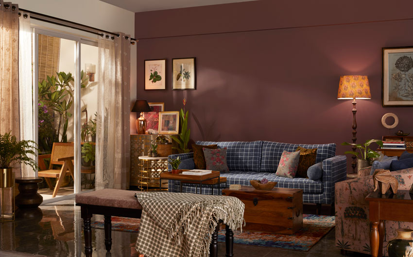 A living room with a blue sofa and a maroon paint