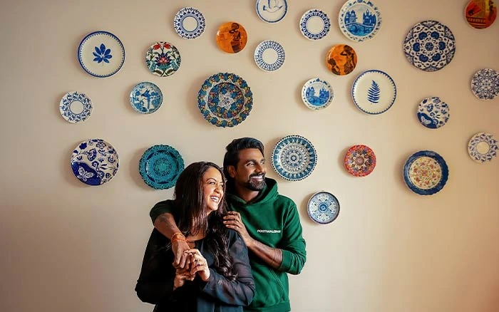 Remo D&rsquo;Souza &amp; his wife Lizelle standing in front of their wall adorned with wall plates - Beautiful Homes